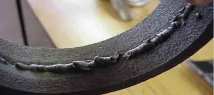 Foto de solda circular em peça metálica com penetração excessiva formando cordão irregular e protuberante