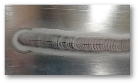 Foto de cordão de solda em chapa com trinca de solidificação ao longo do centro do cordão