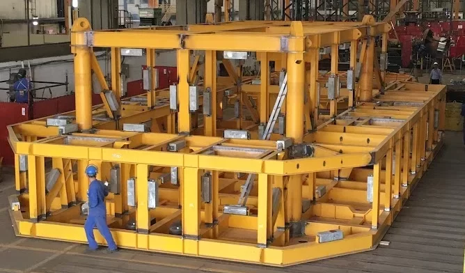 Estrutura metálica caldeirada de grande porte pintada de amarelo em galpão de fabricação
