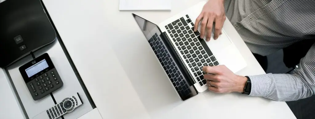 person using laptop on white wooden table